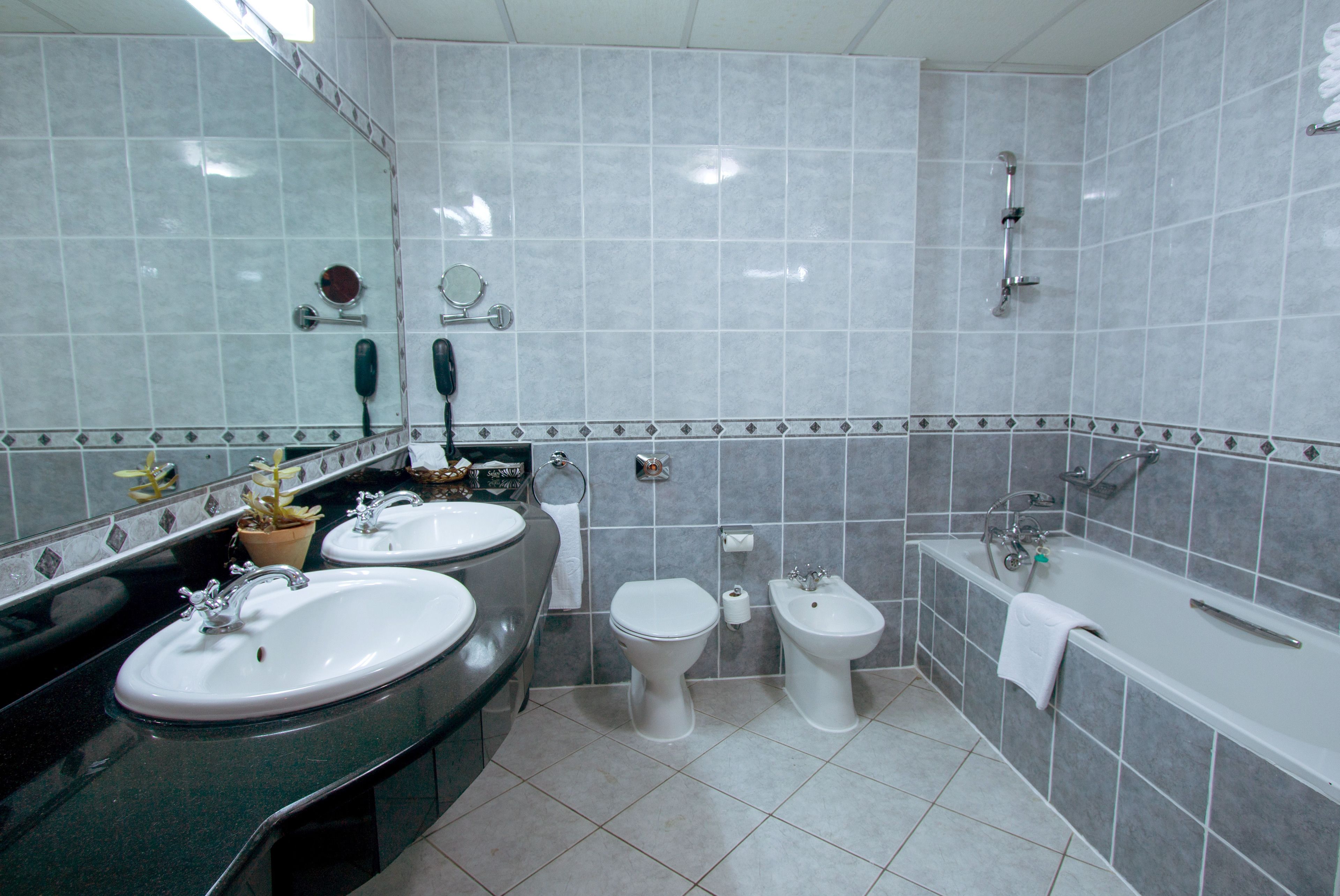 Casa de banho com duas pias, sanita, bidé e banheira.