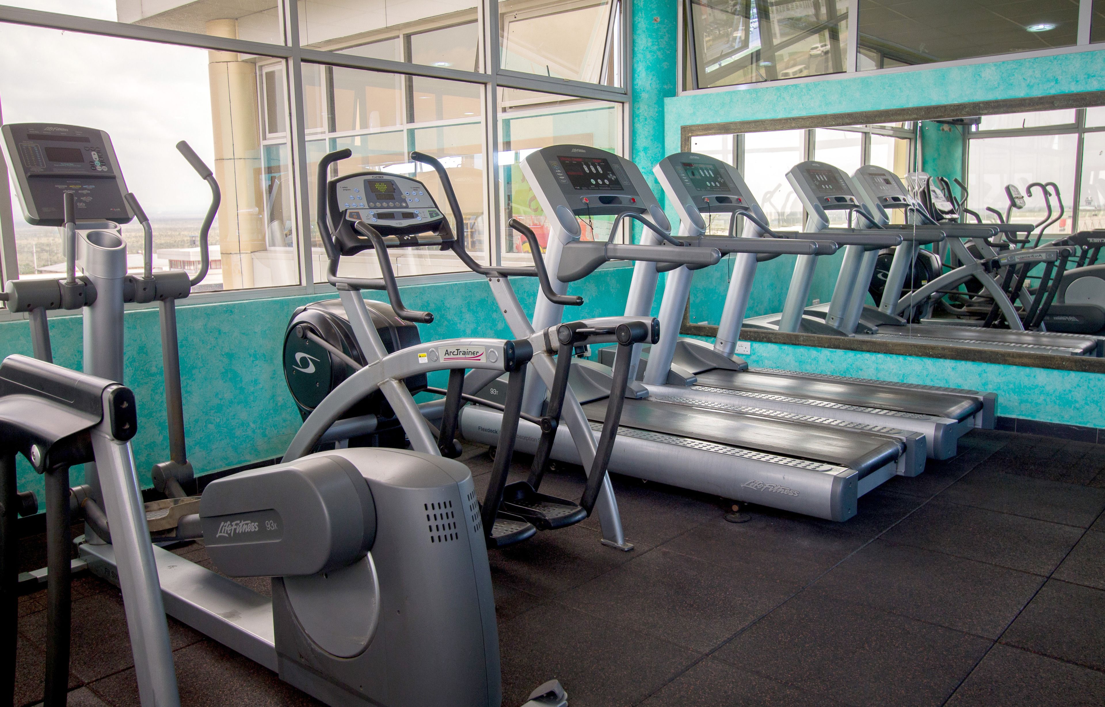A gym with treadmills, elliptical machines, and weight machines.