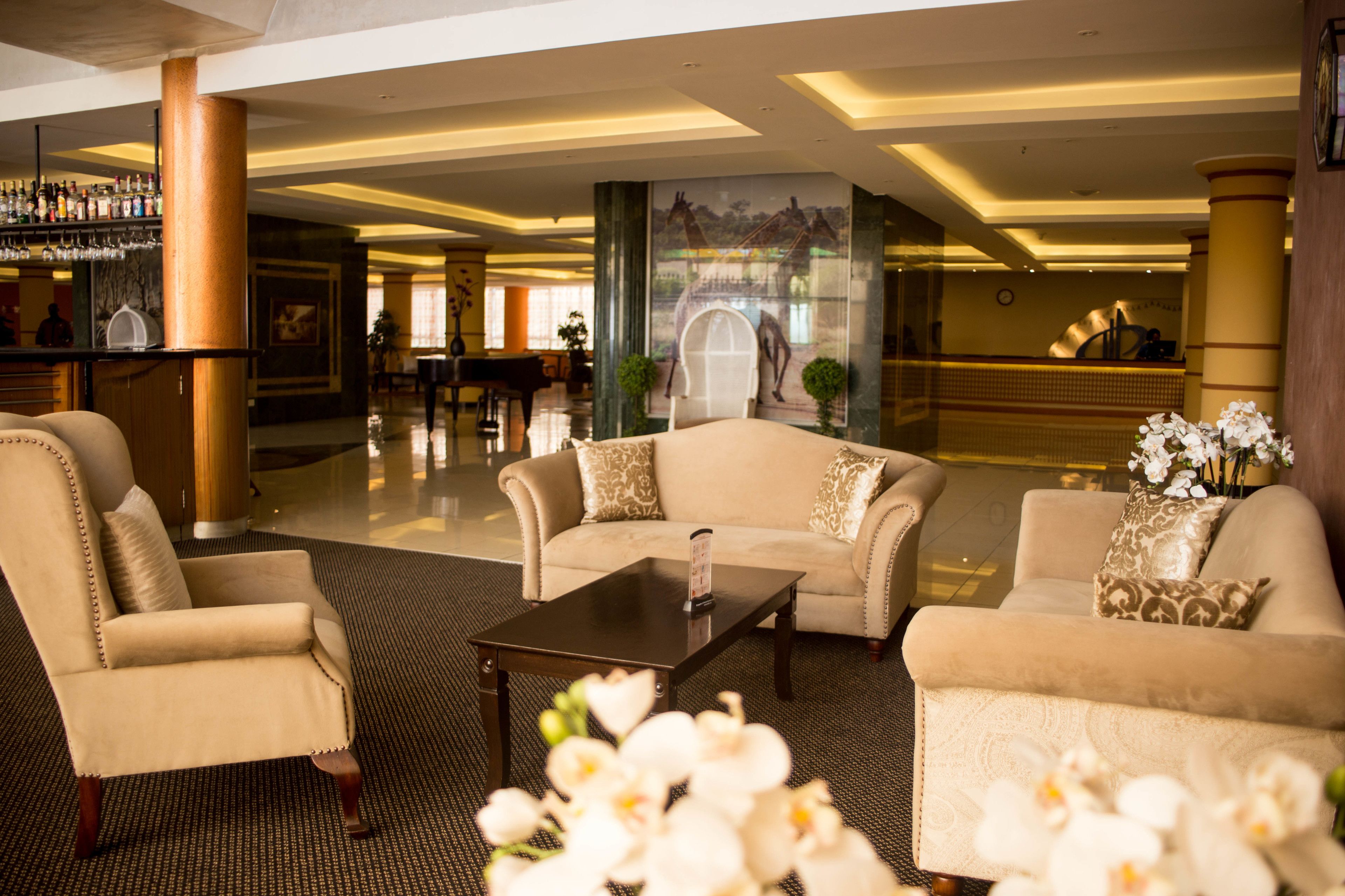 A lobby with a bar area, seating arrangements, and a mural.