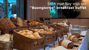 A breakfast buffet with various breads and pastries displayed in wicker baskets. - Residenza Lago di Lugano (Porlezza)