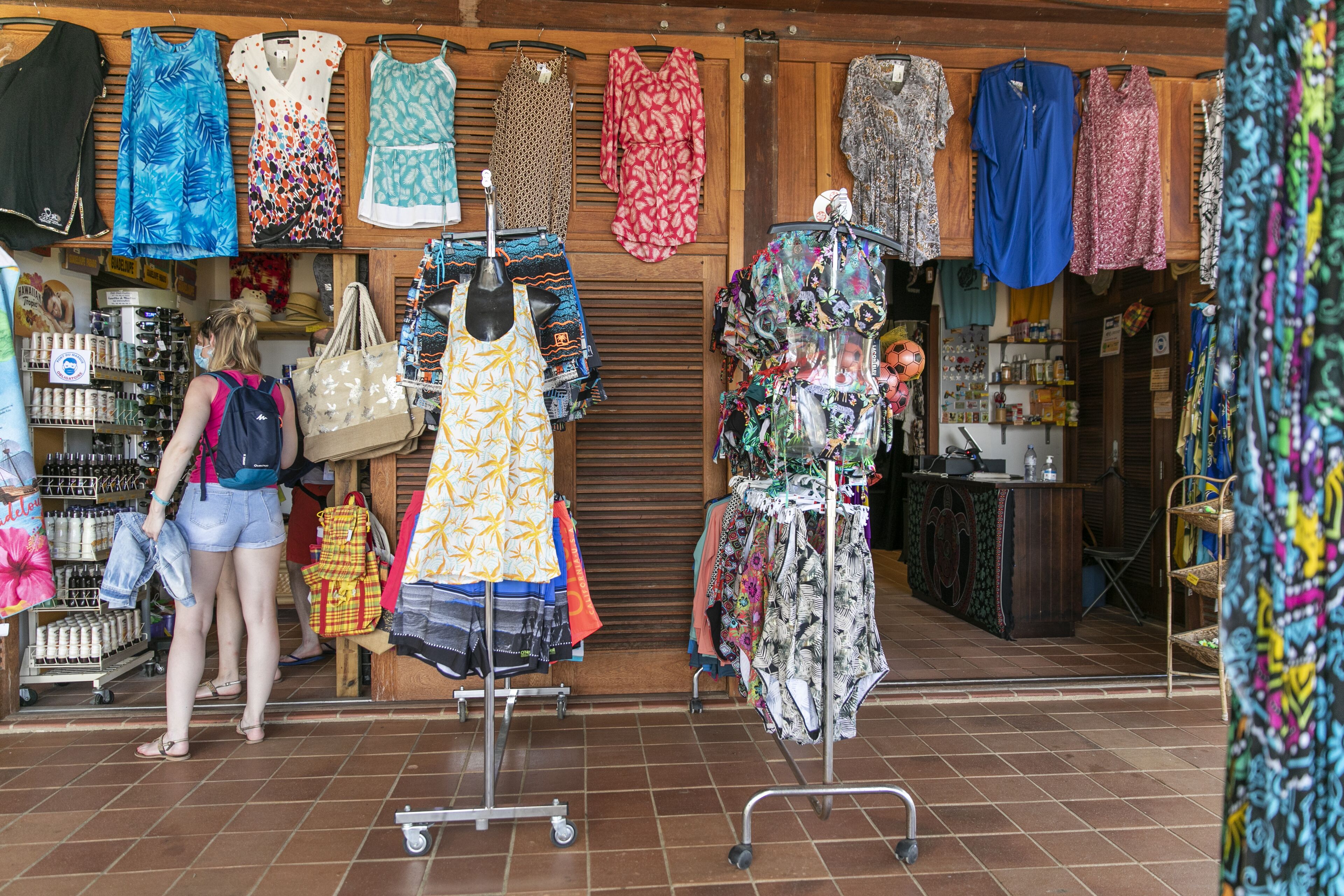 A clothing store with racks of dresses and a display of handbags.