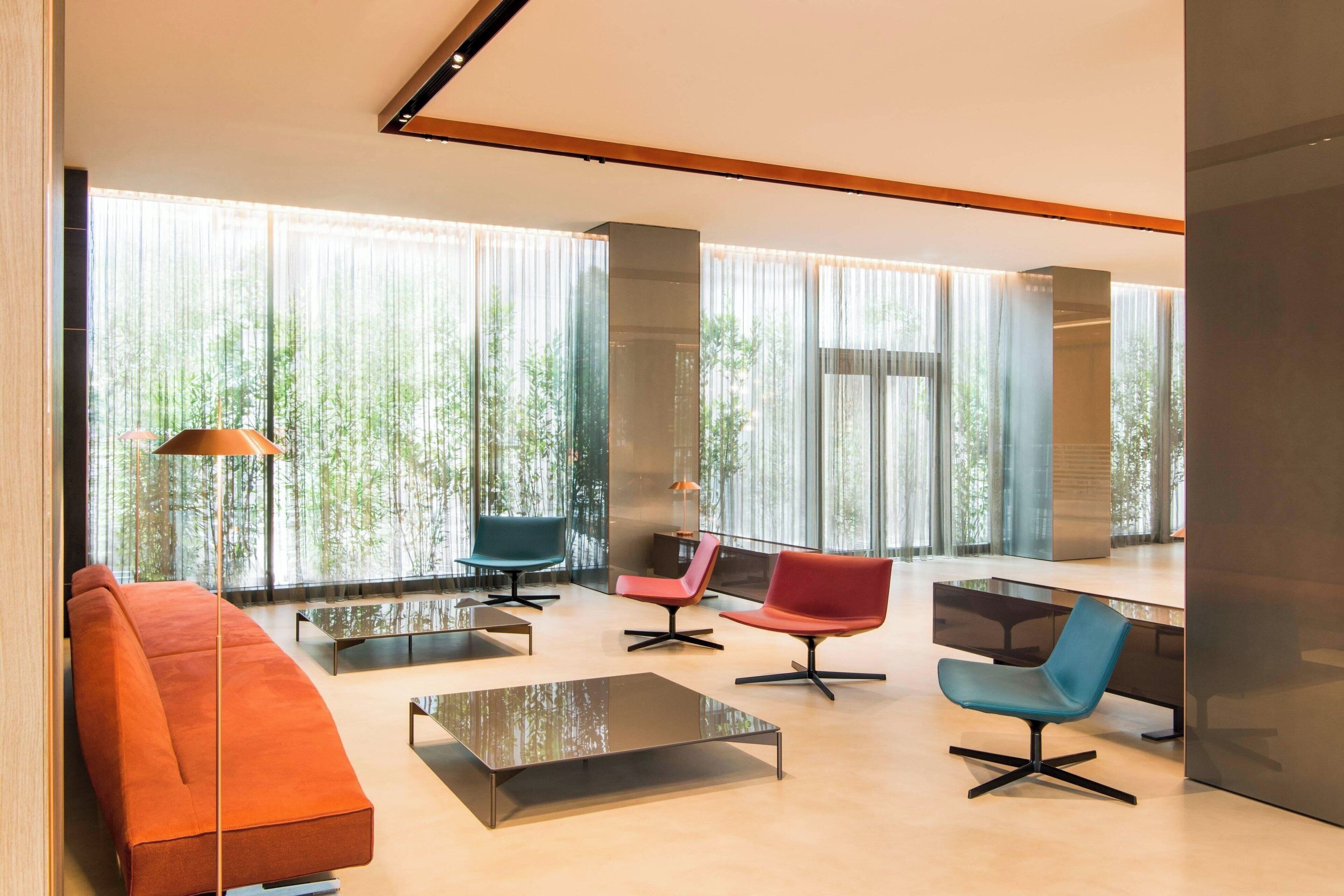 Un salon moderne avec un canapé, des fauteuils et une table basse.