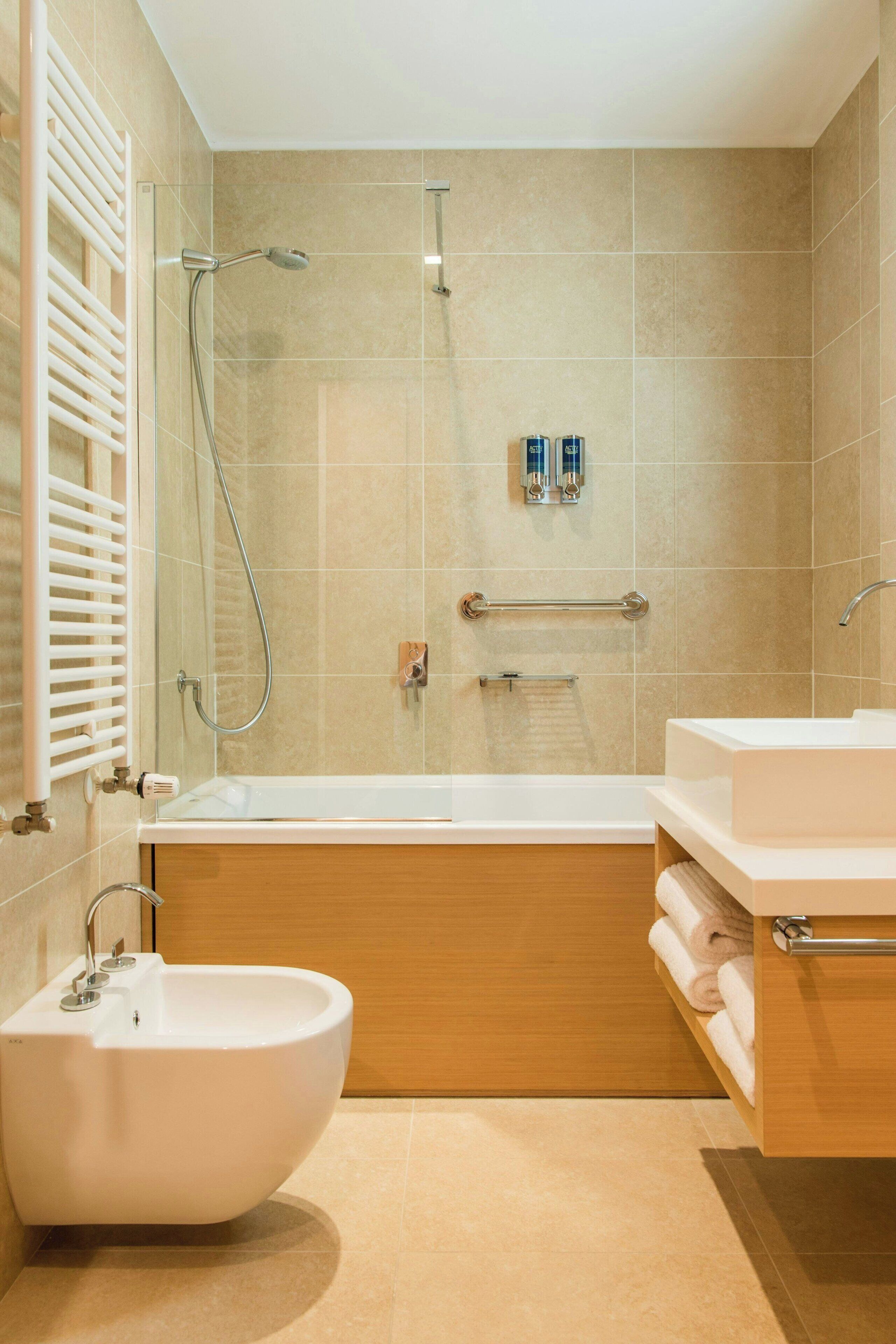 Ein modernes Badezimmer mit freistehender Badewanne, einem Standwaschbecken und einer Dusche mit Handbrause.