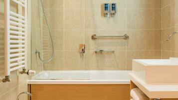 Ein modernes Badezimmer mit freistehender Badewanne, einem Standwaschbecken und einer Dusche mit Handbrause.