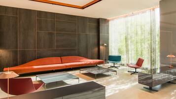 A modern living room with a sectional sofa, a glass coffee table, and a red chair.