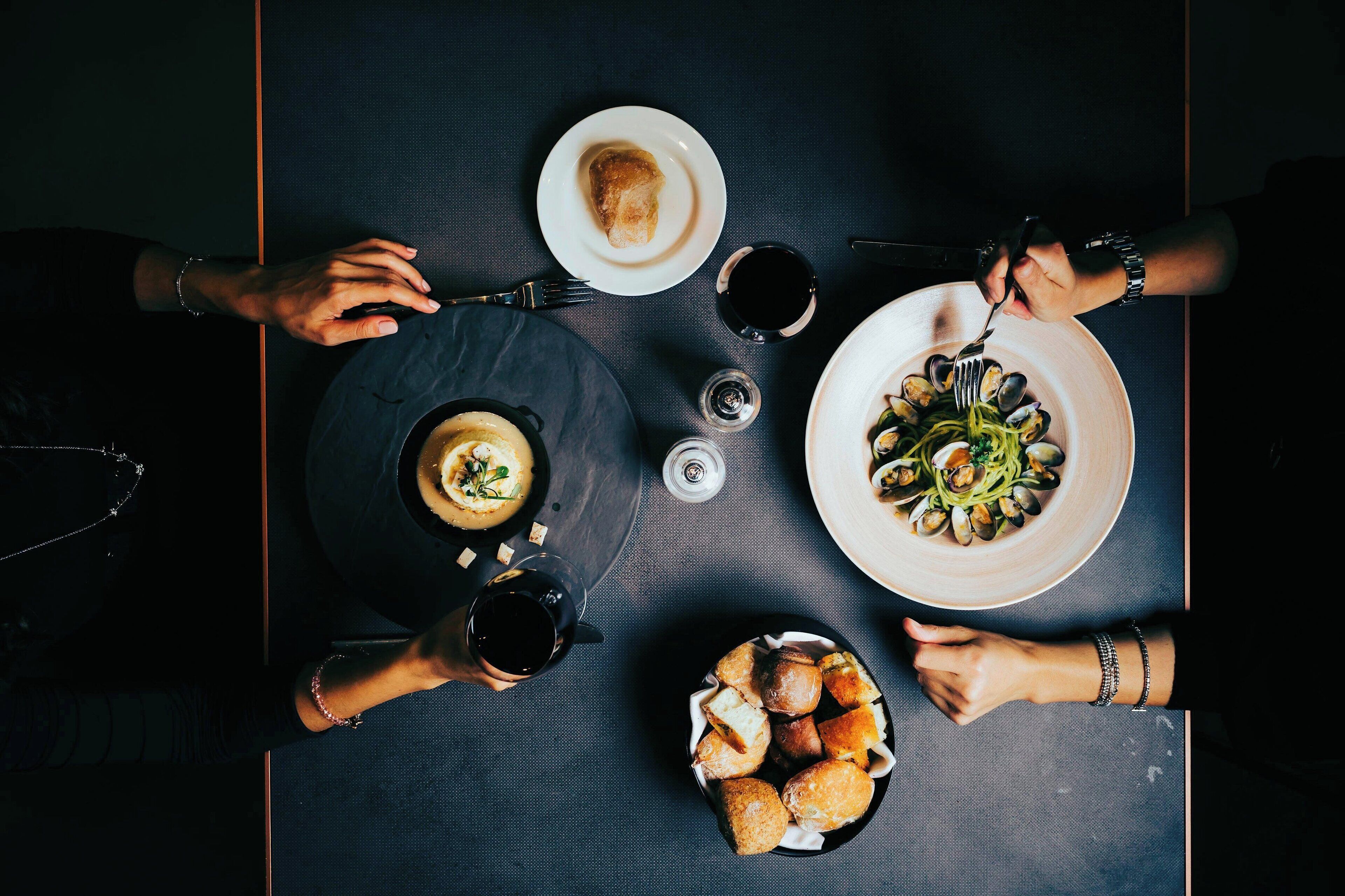 A dining table with various dishes, glasses, and cutlery.