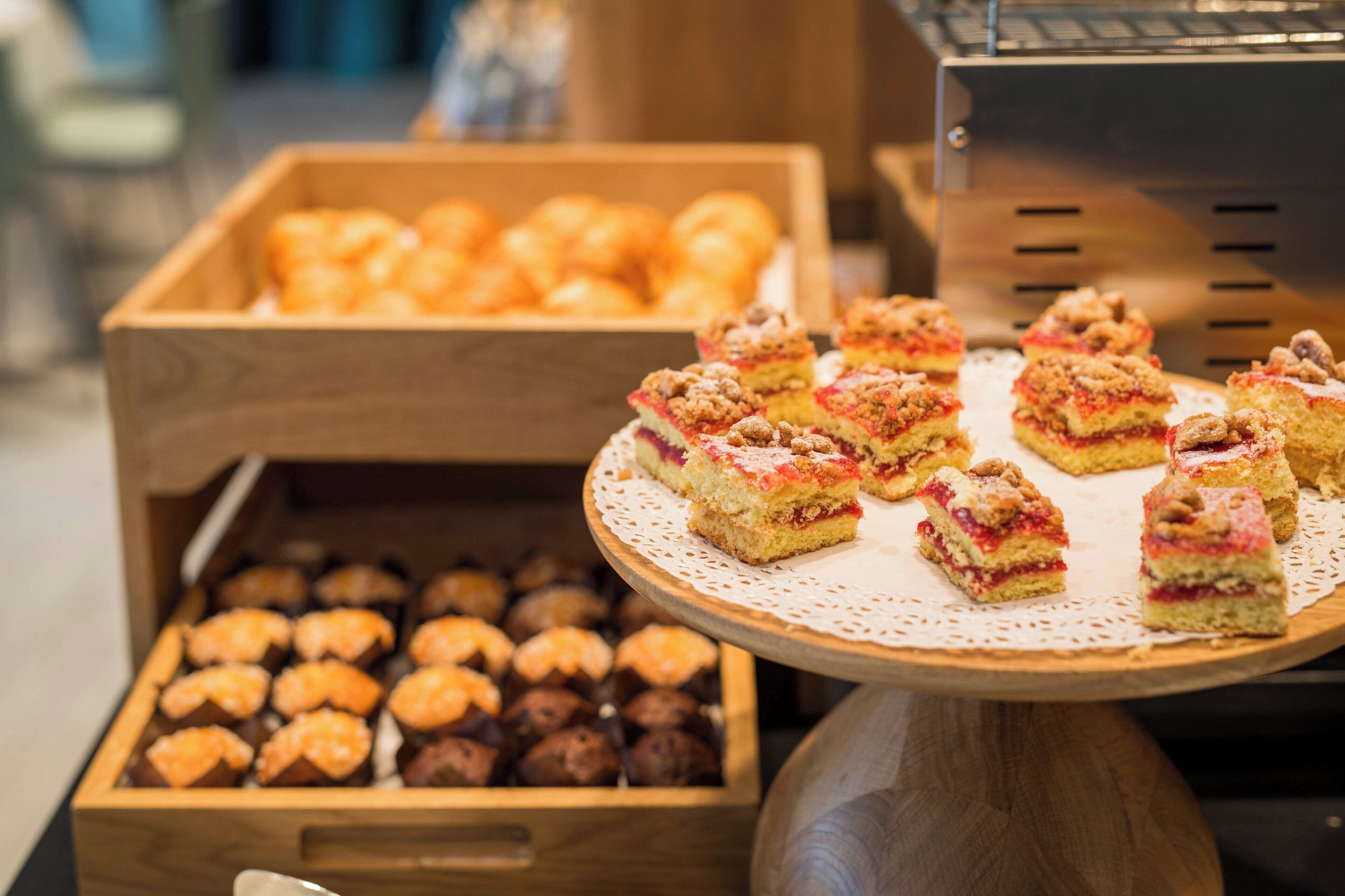 A display of assorted pastries and desserts on a wooden stand.