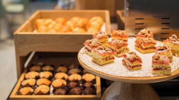 A display of assorted pastries and desserts on a wooden stand.