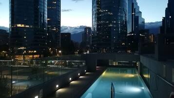 Una piscina al aire libre de temporada, sombrillas