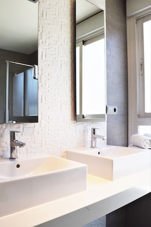 Ein modernes Badezimmer mit zwei Waschbecken, einem großen Spiegel und einem Fenster.
