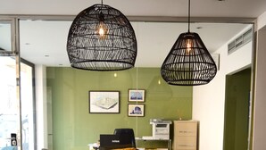 Un salon moderne avec un canapé moutarde, une table basse et deux suspensions noires.