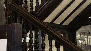 A wooden staircase with balusters and a handrail. - The George Hotel (Cranbrook)