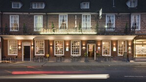 A hotel with a traditional facade, multiple windows, and outdoor seating. - The George Hotel (Cranbrook)