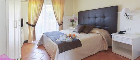 A neatly arranged bedroom with a bed, bedside table, and a nightstand.