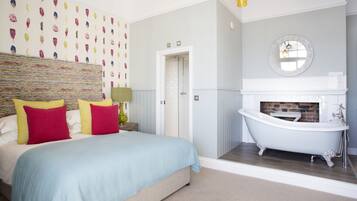 A bedroom with a bed, a bathroom with a bathtub, and a wall with a decorative pattern.