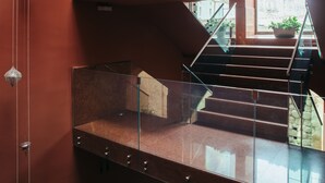 Un intérieur à plusieurs niveaux, doté de rampes en verre et d’escaliers en métal.