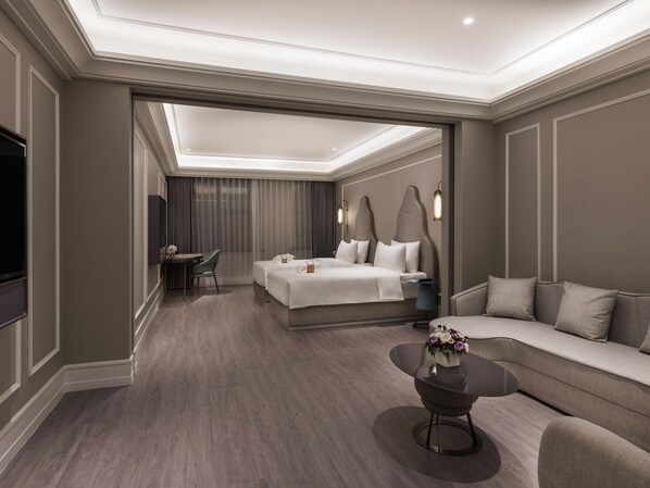 A modern hotel room with a large bed, a sofa, a coffee table, and a TV. - Mercure Shanghai Yu Garden On The Bund (Shanghai)