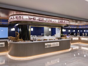 A modern hotel lobby with a curved reception desk, a decorative filmstrip, and a coffee bar. - Mercure Shanghai Yu Garden On The Bund (Shanghai)