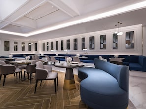 A modern dining area with high ceilings, recessed lighting, and a row of booths and tables. - Mercure Shanghai Yu Garden On The Bund (Shanghai)