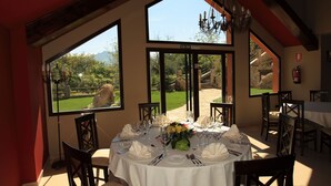 A dining area with a table set for six, large windows, and a view of a garden. - Hotel Zerbinetta (Dilar)
