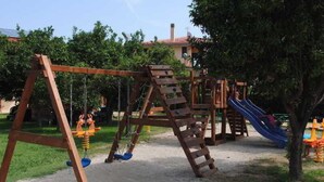 Ein Spielplatz mit Schaukeln und einer Rutsche.