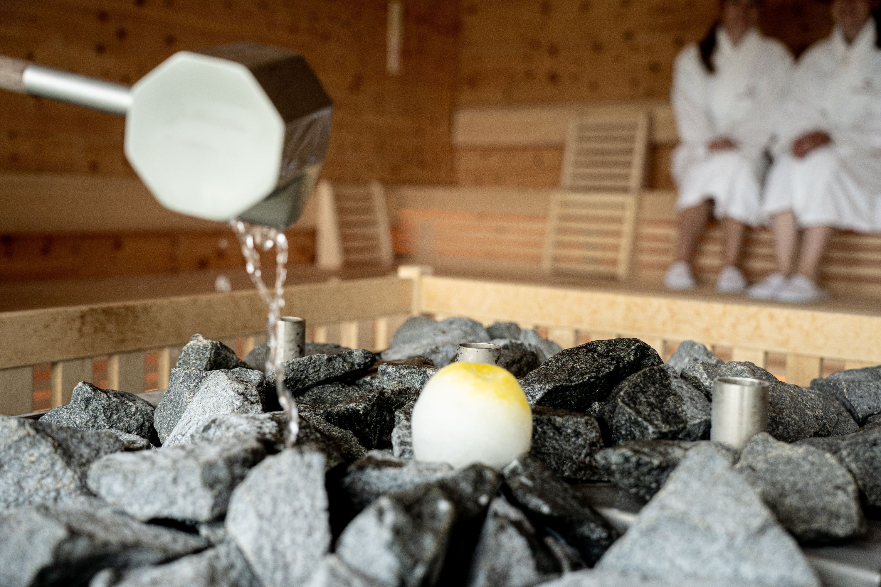 A hot spring bath with rocks and a yellow egg.