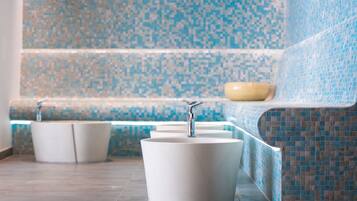Experience a serene bathroom retreat with a minimalist design, featuring a row of sinks and a mosaic tile pattern.