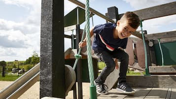 Children can climb and slide in this outdoor play area with a wooden structure and metal slide.