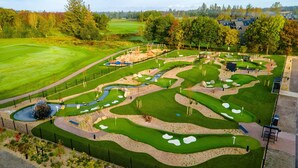 A golf course with multiple holes, sand bunkers, and a water hazard.