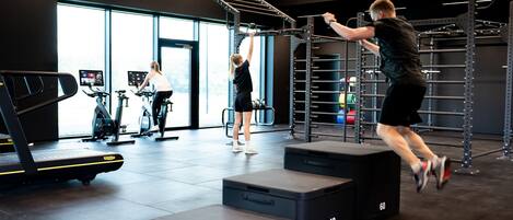 A gym with exercise equipment, treadmills, and a climbing structure.