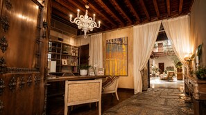 A wooden interior with a chandelier, a stone floor, and a view to an outdoor area. - Gar Anat Hotel Boutique - Domus Artis.  (Granada)