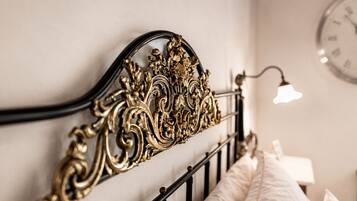 A bed with an ornate metal headboard and a bedside lamp.