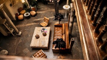 A spacious lounge area with a wooden coffee table, leather sofas, and a decorative plant.
