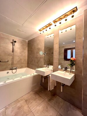 A modern bathroom with a bathtub, two sinks, a shower, and a large mirror. - Gar Anat Hotel Boutique - Domus Artis.  (Granada)