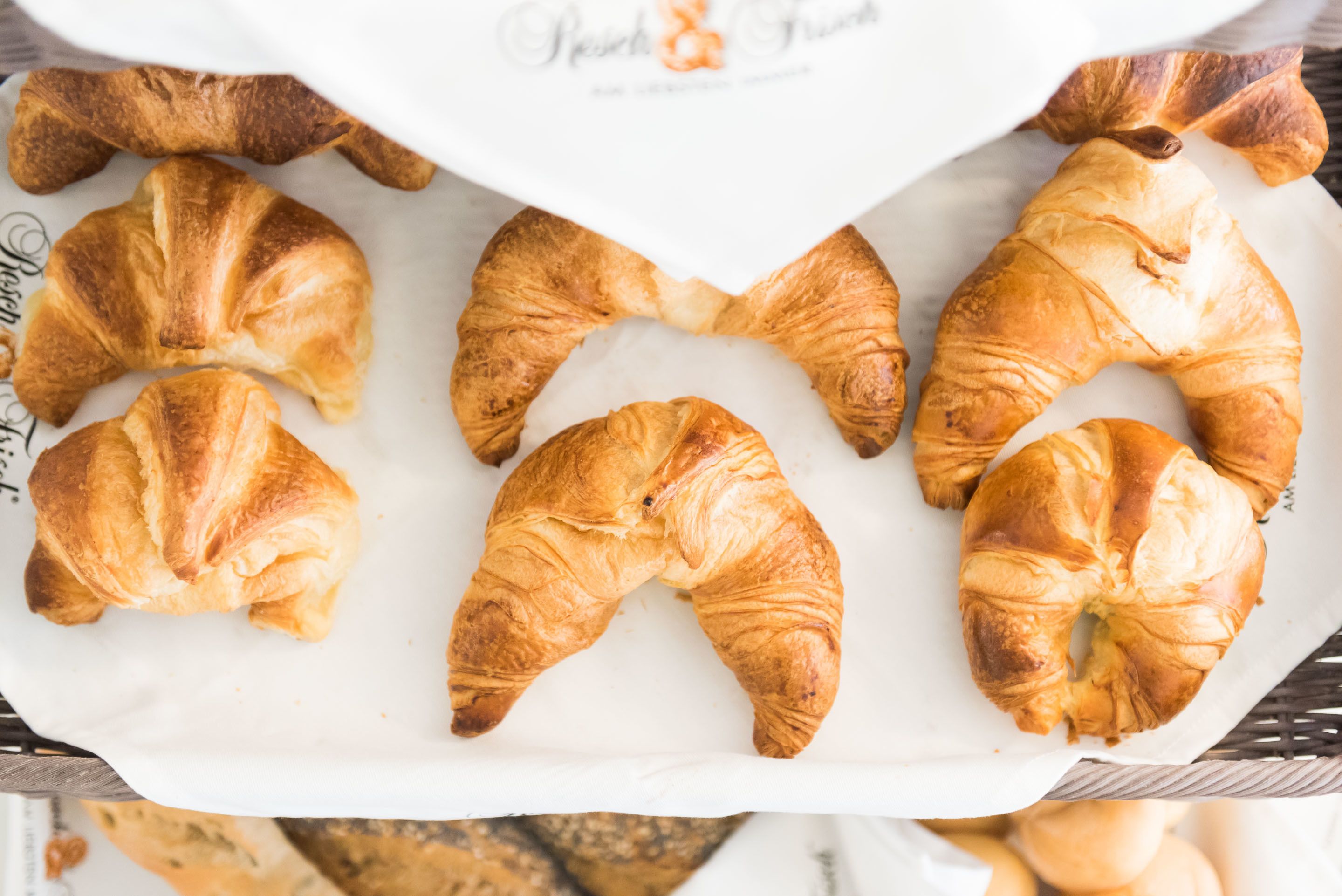 Una bandeja de croissants sobre papel de hornear.