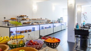 A buffet area with various food items and a seating area with a bicycle mounted on the wall. - Hotel Santoni Freelosophy (Nago-Torbole)
