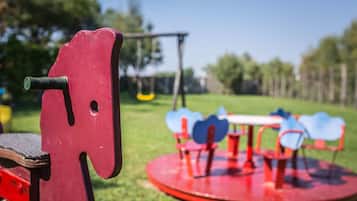 Children can play on the merry-go-round and swing set in this enclosed playground.