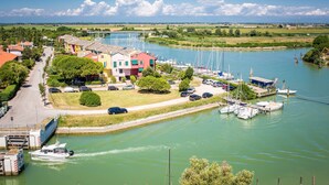 A marina with boats, a road, and buildings. - Hotel San Giorgio (Caorle)