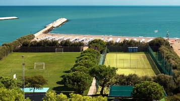 Enjoy tennis on the adjacent court, then relax on the nearby beach with umbrellas and sun loungers.