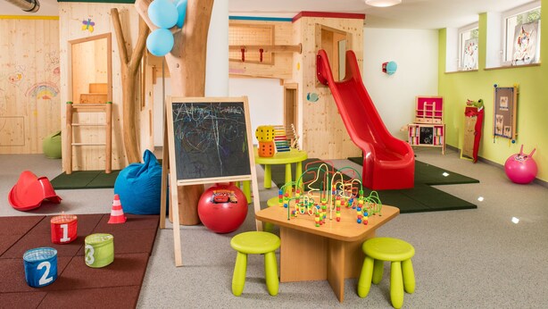 A playroom with a slide, climbing wall, and various toys. - Sporthotel Zoll (Vipiteno)