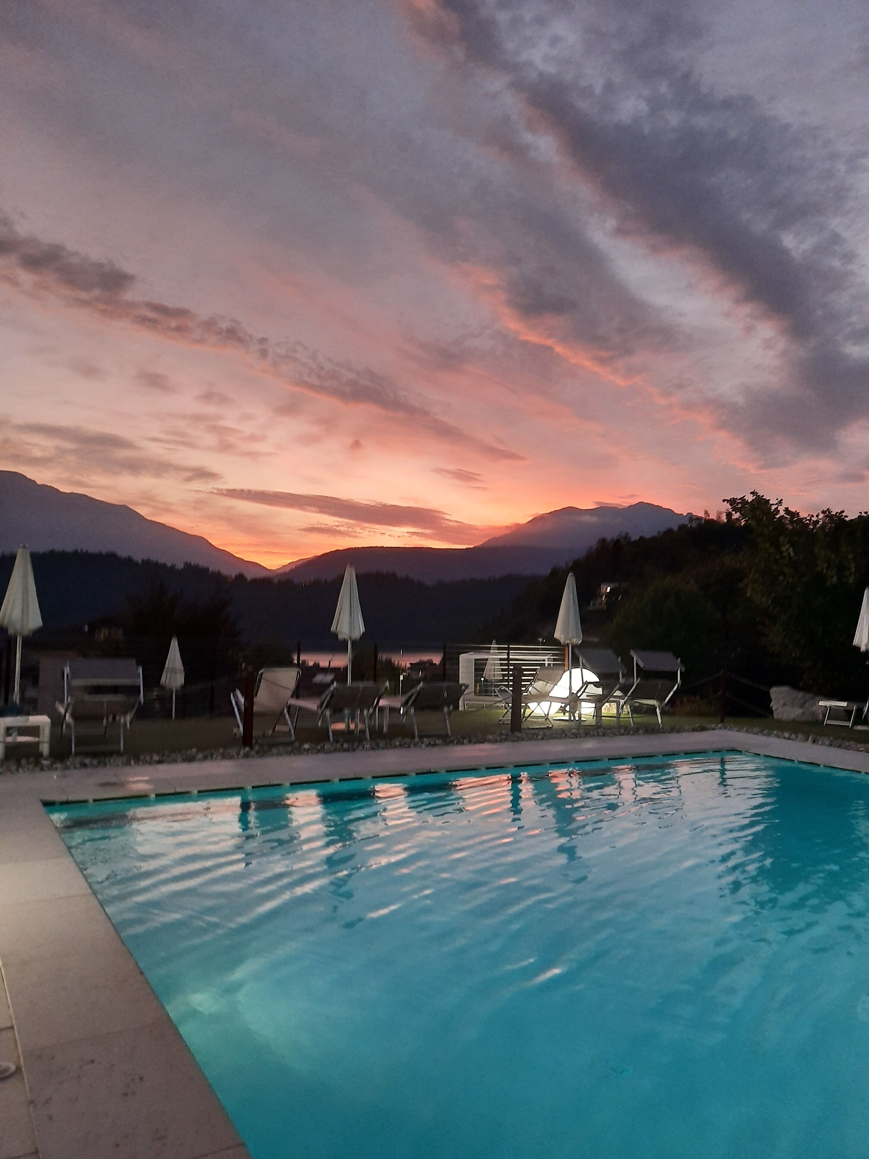 seasonal outdoor pool, a waterfall pool, pool umbrellas, pool loungers