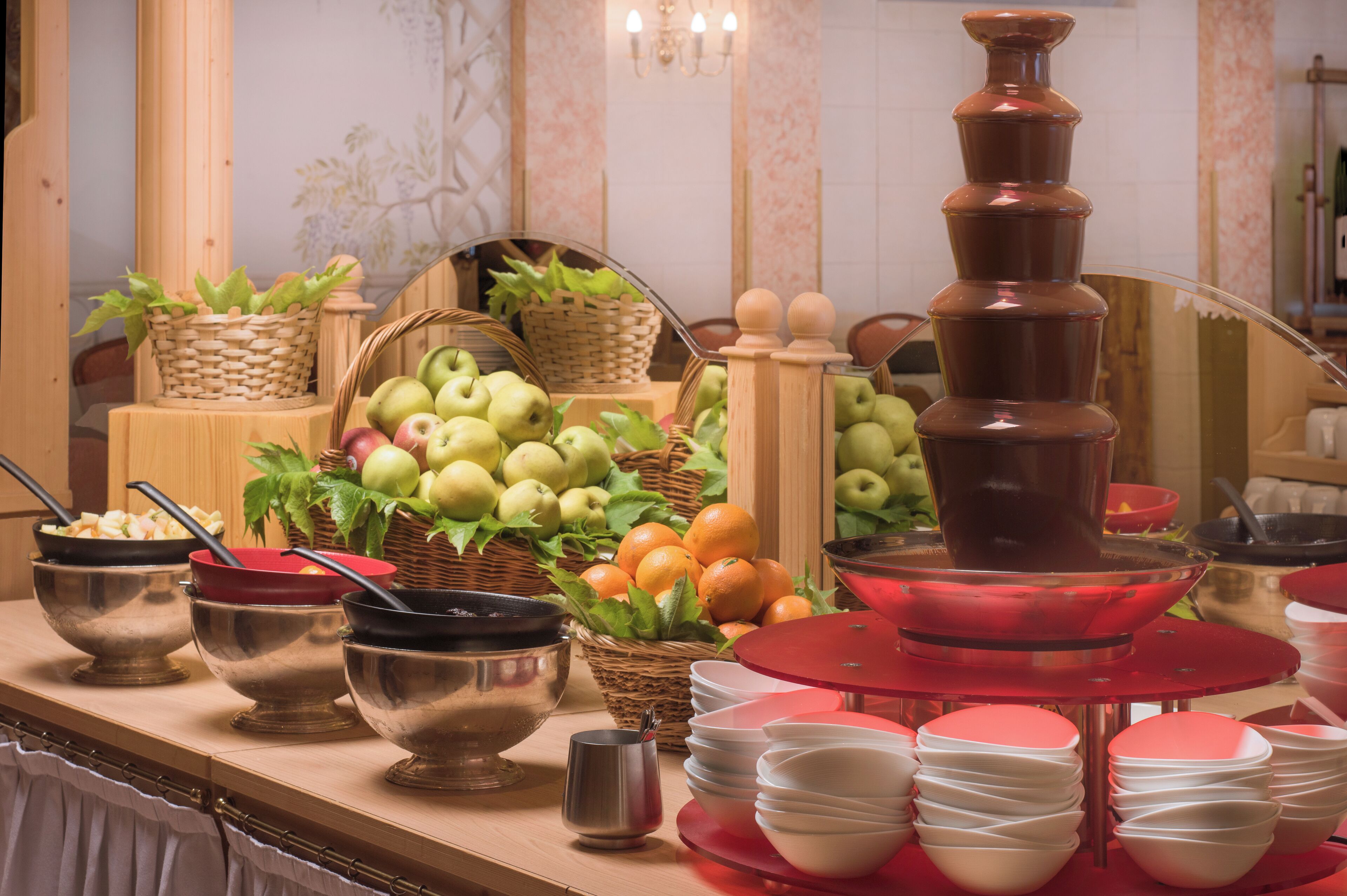 A buffet setup with various food items and serving utensils.