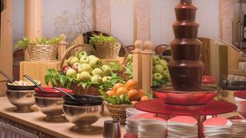 A buffet setup with various food items and serving utensils.
