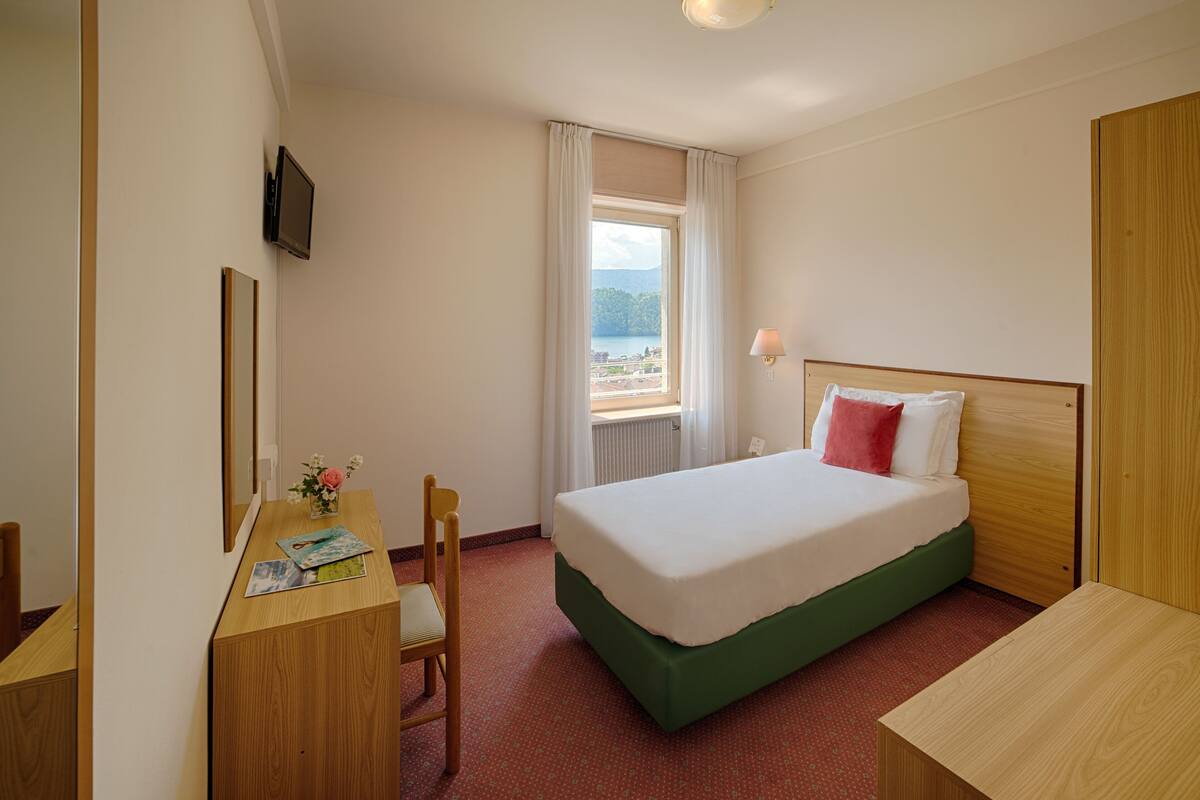 Ein Hotelzimmer mit Bett, Schreibtisch, Stuhl, Fernseher und Fenster mit Blick.