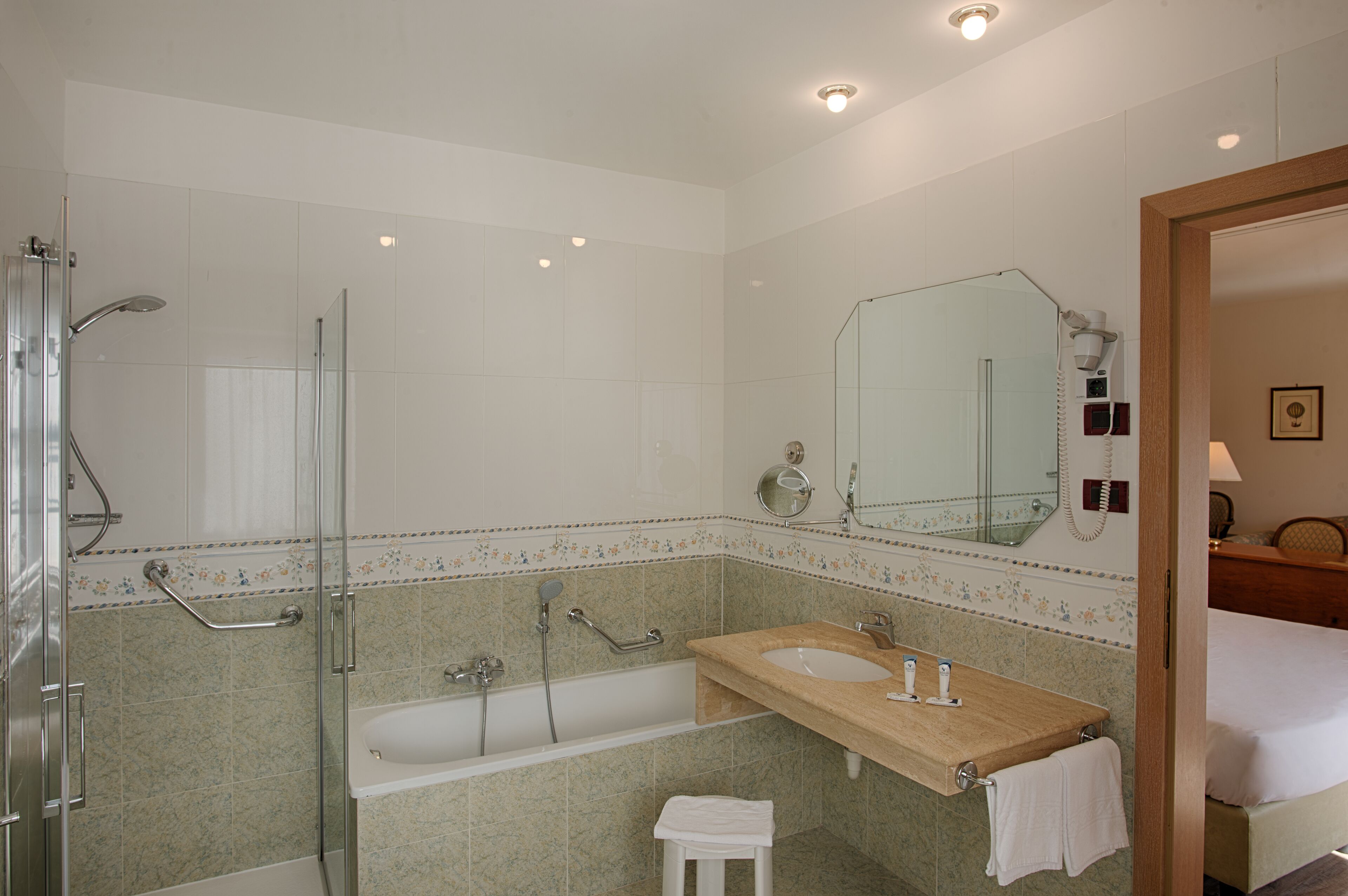 Un baño moderno con ducha de vidrio, una bañera independiente, un lavabo y un espejo grande.