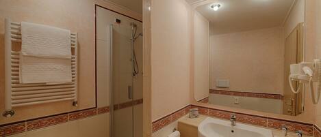 A bathroom with a glass-enclosed shower, a sink with a mirror, and a towel rack with folded towels.