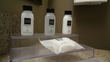 En badrumsbänk med tre flaskor från produktserien White Water Collection: balsam, schampo och lotion.