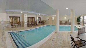 An indoor swimming pool with lounge chairs and a sunbed area. - Hampton Inn Rochester Webster (Webster)