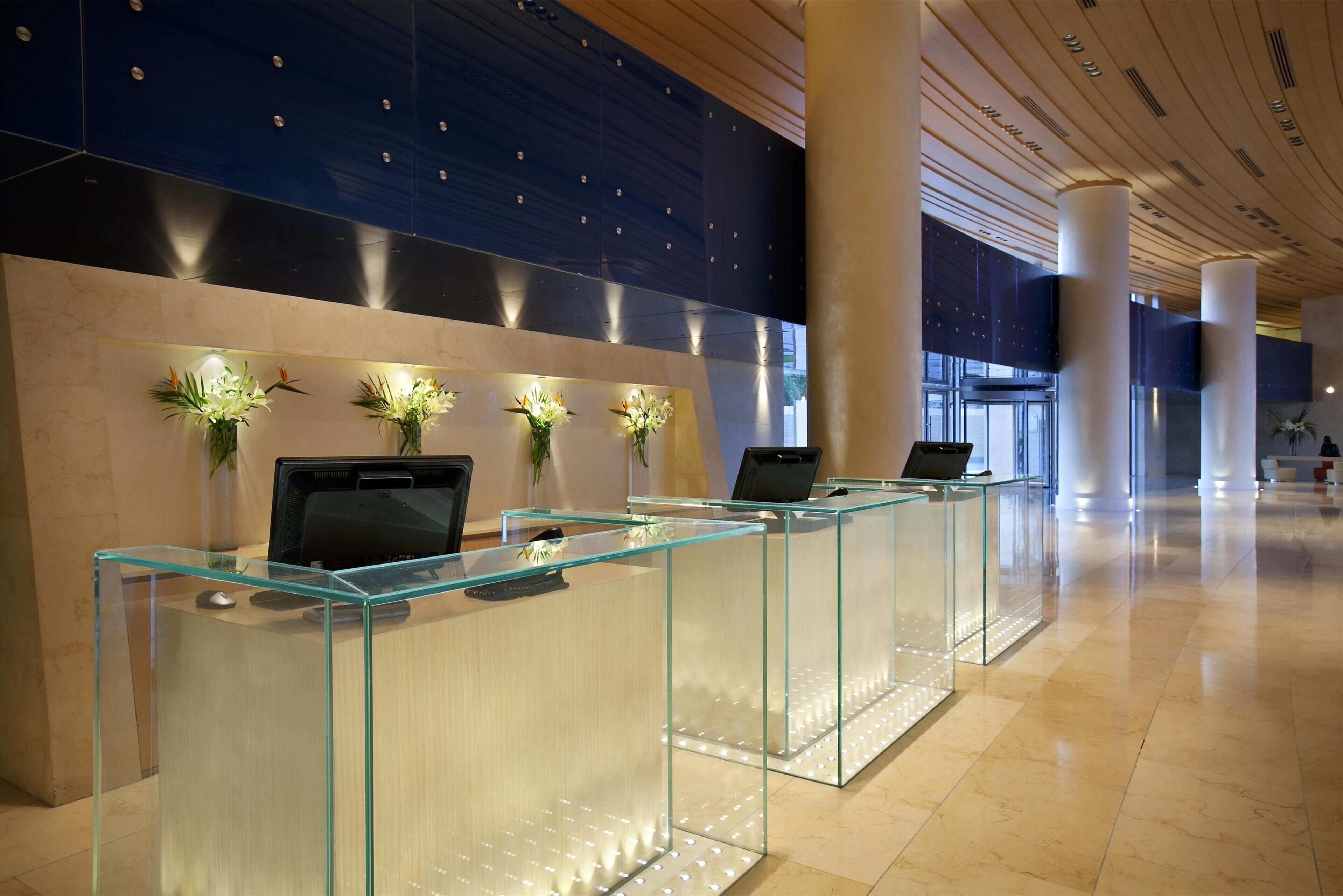 A reception area with glass counters, a dark wall with a pattern, and a tiled floor.