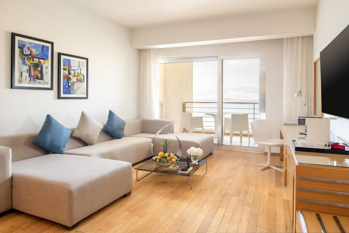 A modern living room with a sofa, coffee table, and artwork on the wall.